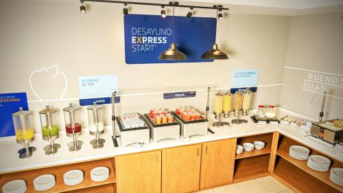 a coffee shop with a counter with food and drinks at Holiday Inn Express Chihuahua by IHG in Chihuahua