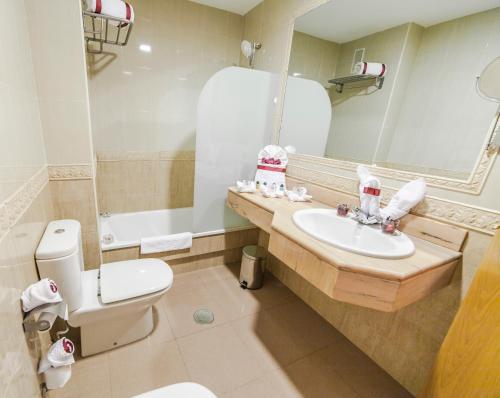 a bathroom with a sink and a toilet and a mirror at Hotel Regio 2 in Cádiz