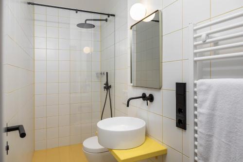 uma casa de banho branca com um lavatório e um espelho em 95sqm 4 room maisonette apt near center & PrenzlB em Berlim