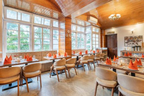 een restaurant met tafels en stoelen met oranje kegels erop bij Summit Alpine Abode Hotel Centrally Air Conditioned in Gangtok