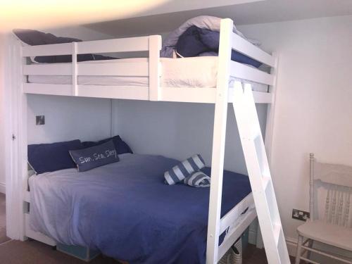 two bunk beds in a room with a bed at Tudor Apartment (Panoramic Sea Views) in Trearddur