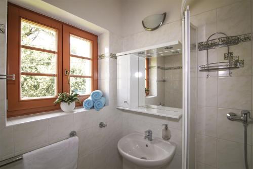 a white bathroom with a sink and a mirror at Penzion Linden in Oldřiš