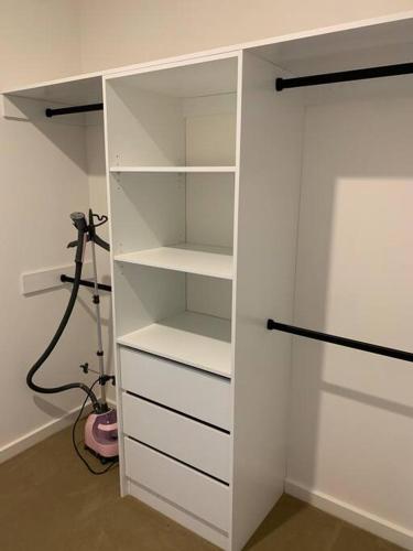 a white closet with white shelves in a room at ‘The bayside’ Beautifully brand new house in Mentone