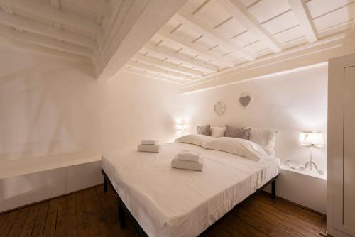 - une chambre blanche avec un grand lit aux murs blancs dans l'établissement Toscanella Romantic, à Florence