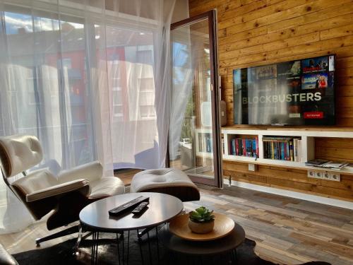 a living room with a tv and a table and chairs at Living at Saarpartments -Adults Only- 2 Bedrooms, Netflix - Business & Holiday Apartments for Long- and Short term Stay, 3 min to Train Station and Europa Galerie in Saarbrücken