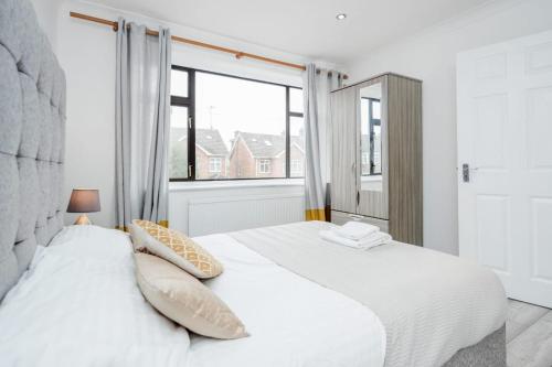 1 dormitorio con 2 camas y ventana grande en 3 Bedroom house with garden and free parking en Brentwood