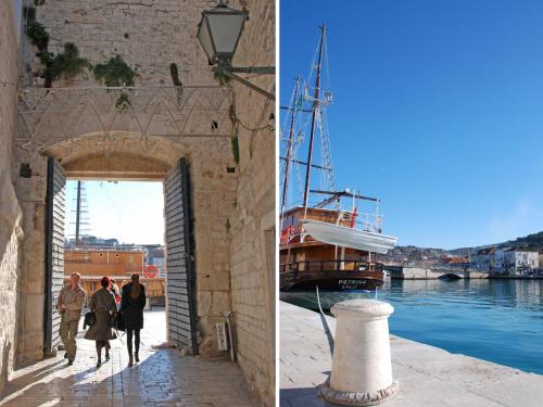 a couple of people walking through an archway next to a boat at Studios Magnolia in Trogir