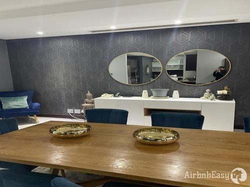 a dining room with a table and two mirrors at Luxury Apartment - Michelangelo Towers in Johannesburg