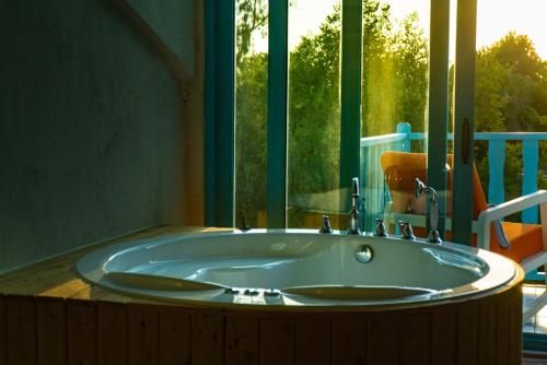 a large tub in a bathroom with a window at Yonca Lodge in Fethiye