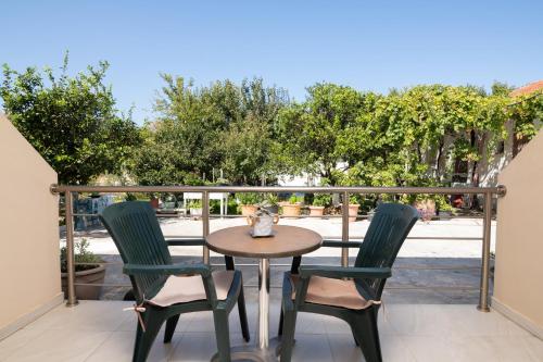 een tafel en stoelen op een balkon met bomen bij Maria’s room in Argassi