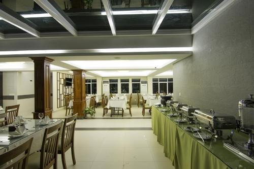 a restaurant with tables and chairs in a room at Rose Emerald Hotel in Phnom Penh