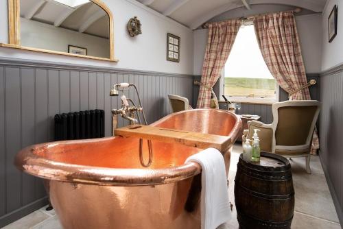 a copper tub in a bathroom with a window at Wagtail in Greenhead