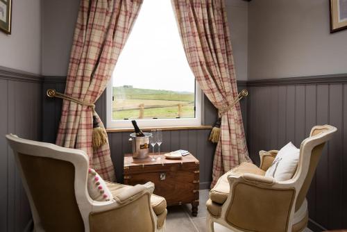 a living room with two chairs and a window at Wagtail in Greenhead