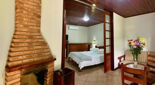 a bedroom with a bed and a fireplace at Pousada Caminho das Candeias in Lumiar