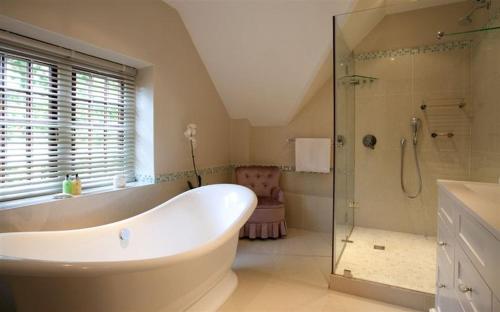 a bathroom with a large tub and a shower at Vredenburg Manor House in Somerset West