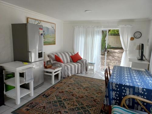 a living room with a couch and a table at Onrus Garden Cottage, Sunny and Spacious in Hermanus