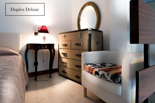 パリにあるグラン オテル ドゥ ベルエアのベッドルーム1室(ドレッサー、ベッド横の椅子付)