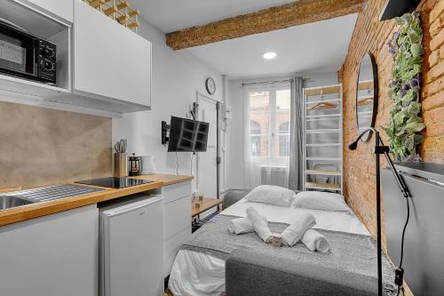 - une petite cuisine avec un lit dans une chambre dans l'établissement Getaway For 2 Beautiful Studio Near The Garonne, à Toulouse