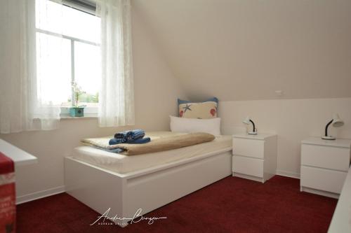 ein kleines Schlafzimmer mit einem Bett und einem Fenster in der Unterkunft Pension Lütje Huske Zimmer 3 in Südbrookmerland