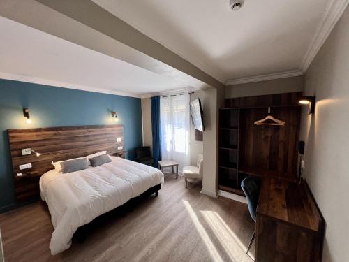 ヴィトリー・ル・フランソワにあるLogis Hôtel Spa la Posteのベッドルーム1室(大型ベッド1台、木製ヘッドボード付)