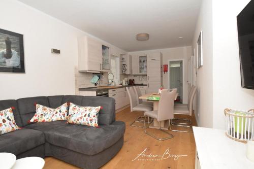 ein Wohnzimmer mit einem Sofa und einer Küche in der Unterkunft Pension Lütje Huske Zimmer4 in Südbrookmerland