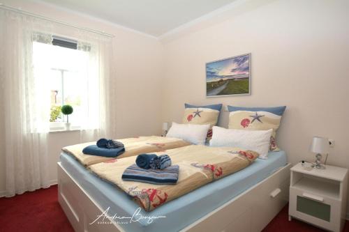 ein Schlafzimmer mit einem Bett mit Handtüchern darauf in der Unterkunft Pension Lütje Huske Zimmer 1 in Südbrookmerland