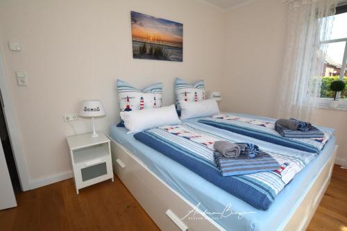 a bedroom with a bed with blue and white pillows at Pension Lütje Huske Zimmer 2 in Südbrookmerland