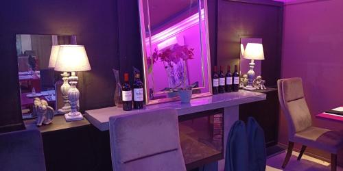 a purple room with a table with bottles of wine at L'Address in Cotonou