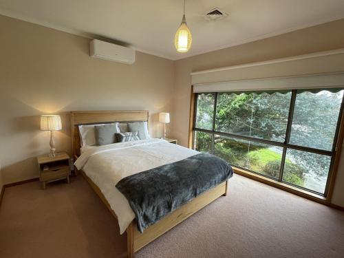 een slaapkamer met een groot bed en een groot raam bij BEAUTIFUL BAY VIEWS in Dromana