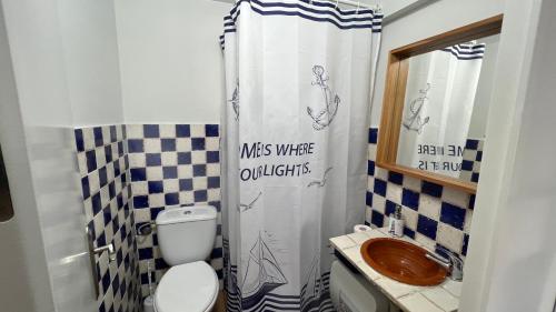 a bathroom with a toilet and a shower curtain at Acogedor estudio entrada independiente junto playa in El Puerto de Santa María