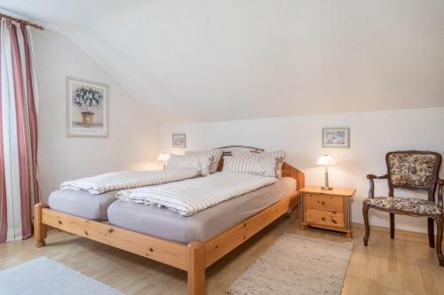 ein Schlafzimmer mit einem großen Bett und einem Stuhl in der Unterkunft Annemarie und Walter Hechelmann in Lindau