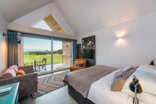 a bedroom with a bed and a balcony with a table at Lodges at Whitekirk Hill some with Hot Tubs - North Berwick in Whitekirk