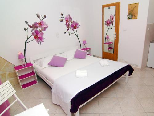 a bedroom with a bed with flowers on the wall at Studios Magnolia in Trogir