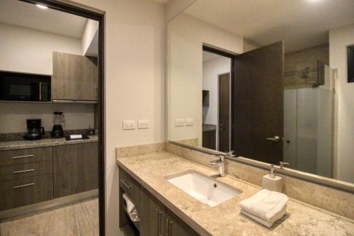 baño con lavabo y espejo grande en Syrena 503 en Playa del Carmen