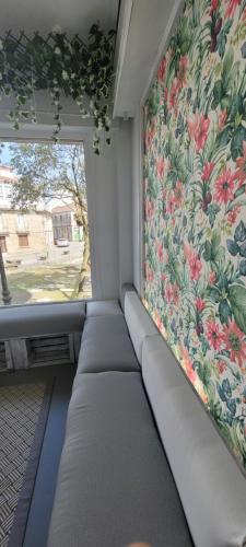 a room with a window with a floral curtain at ALBERGUE de Caldas de Reis URRACA in Caldas de Reis