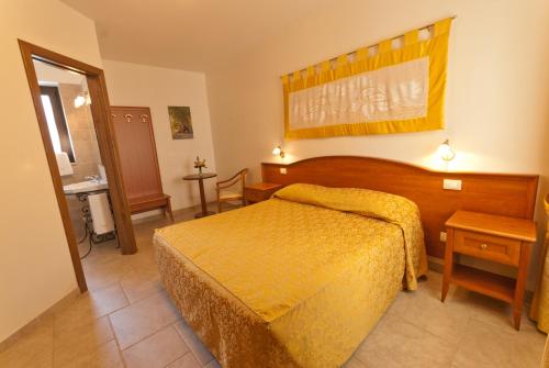 ein Schlafzimmer mit einem Bett mit gelber Tagesdecke in der Unterkunft La Piccola Corte in Alberobello