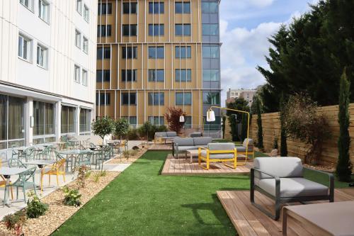 a courtyard with tables and chairs and a building at ibis Dijon Gare in Dijon