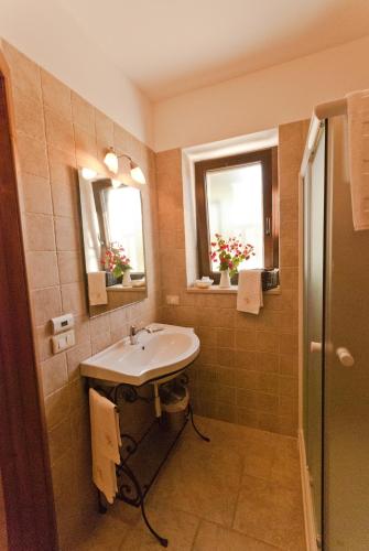 a bathroom with a sink and two windows at La Piccola Corte in Alberobello