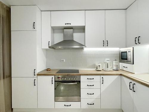 a kitchen with white cabinets and a stove top oven at Fenix 2 Bedroom Apartment Varna Center in Varna City