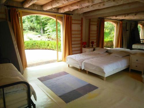 ein Schlafzimmer mit einem Bett und einem großen Fenster in der Unterkunft Villa de 4 chambres avec piscine privee terrasse amenagee et wifi a Jurancon in Jurançon