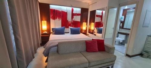 een slaapkamer met een groot bed en een bank bij Flat International Business Ibirapuera, 2534 Moema in Sao Paulo