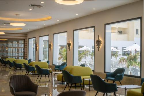 a waiting room with chairs and tables and windows at Dar Khayam in Hammamet