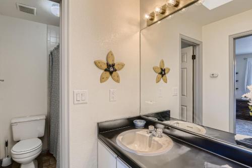 a bathroom with a sink and a toilet and a mirror at RARE FIND Modern Townhome in the Heart of Old Colorado City in Colorado Springs