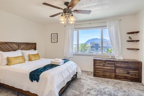 a bedroom with a bed with a ceiling fan and a window at RARE FIND Modern Townhome in the Heart of Old Colorado City in Colorado Springs