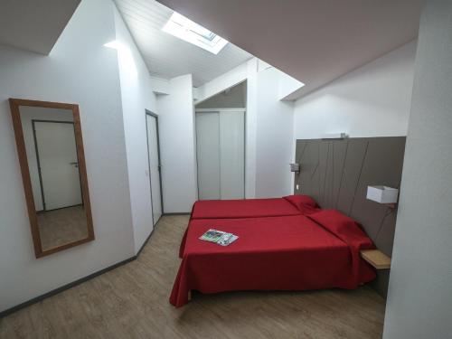 a bedroom with a red bed and a mirror at Résidence Mer & Golf Sokoburu in Hendaye