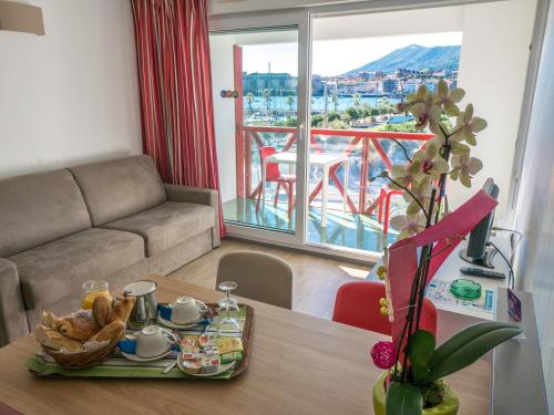 a living room with a table with a tray of food at Résidence Mer & Golf Sokoburu in Hendaye