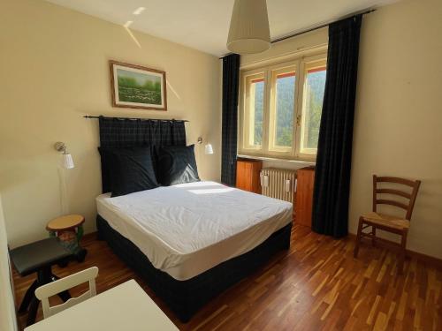 a bedroom with a bed and a chair in it at The Panoramico in Sauze dʼOulx
