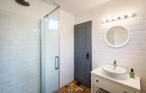 a bathroom with a sink and a glass shower at Borárium Vendégházak - Néró Ház in Pázmánd