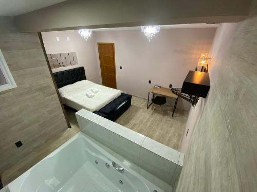 a bathroom with a tub and a bed in a room at Pousada Leitzke in Piratini