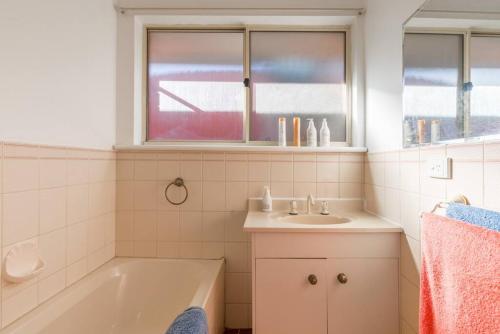 a bathroom with a bath tub and a sink at ParkViewAtMontagueFarm in Mawson Lakes